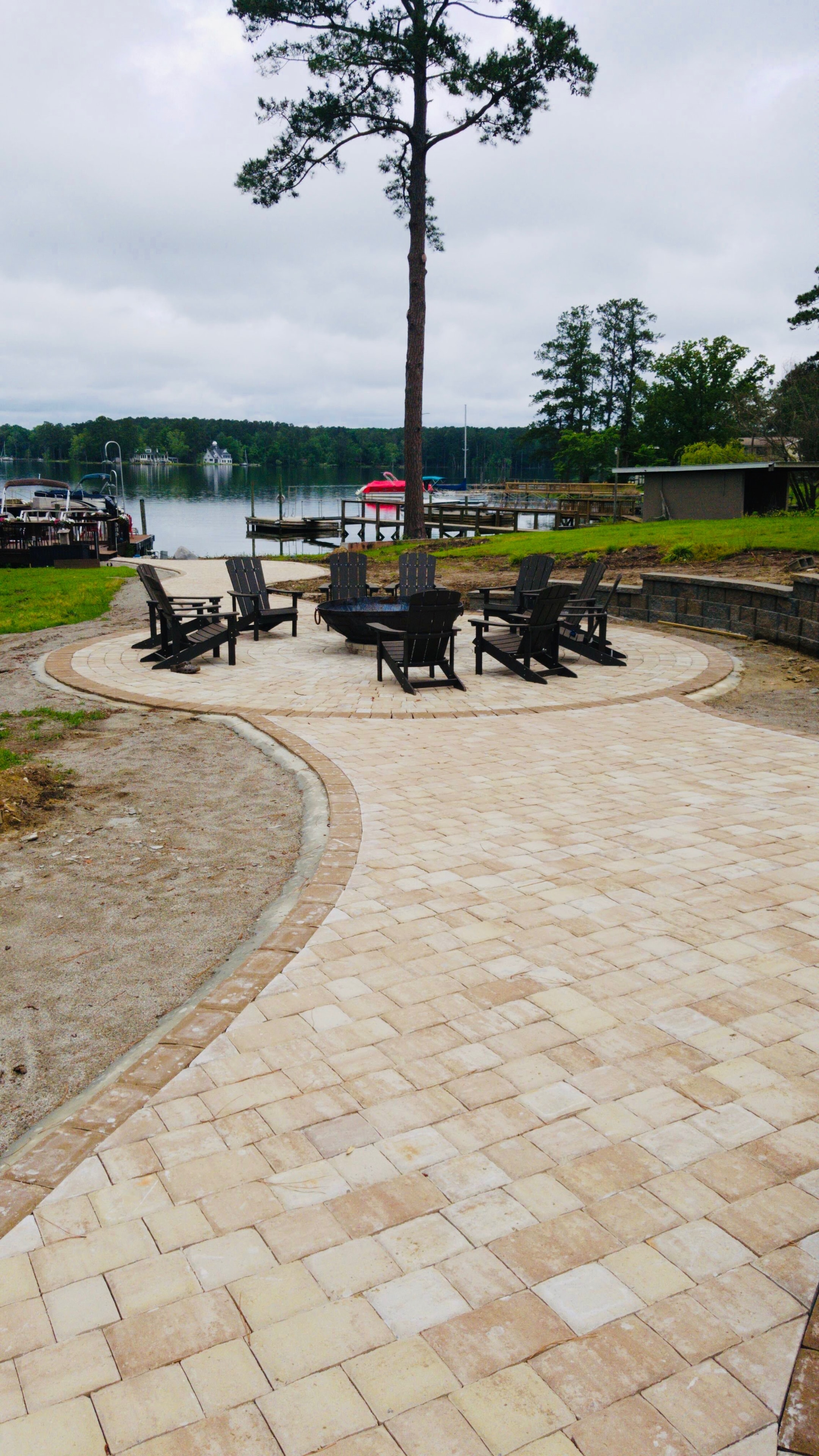 Lakeside patio with fire pit and adirondack chairs