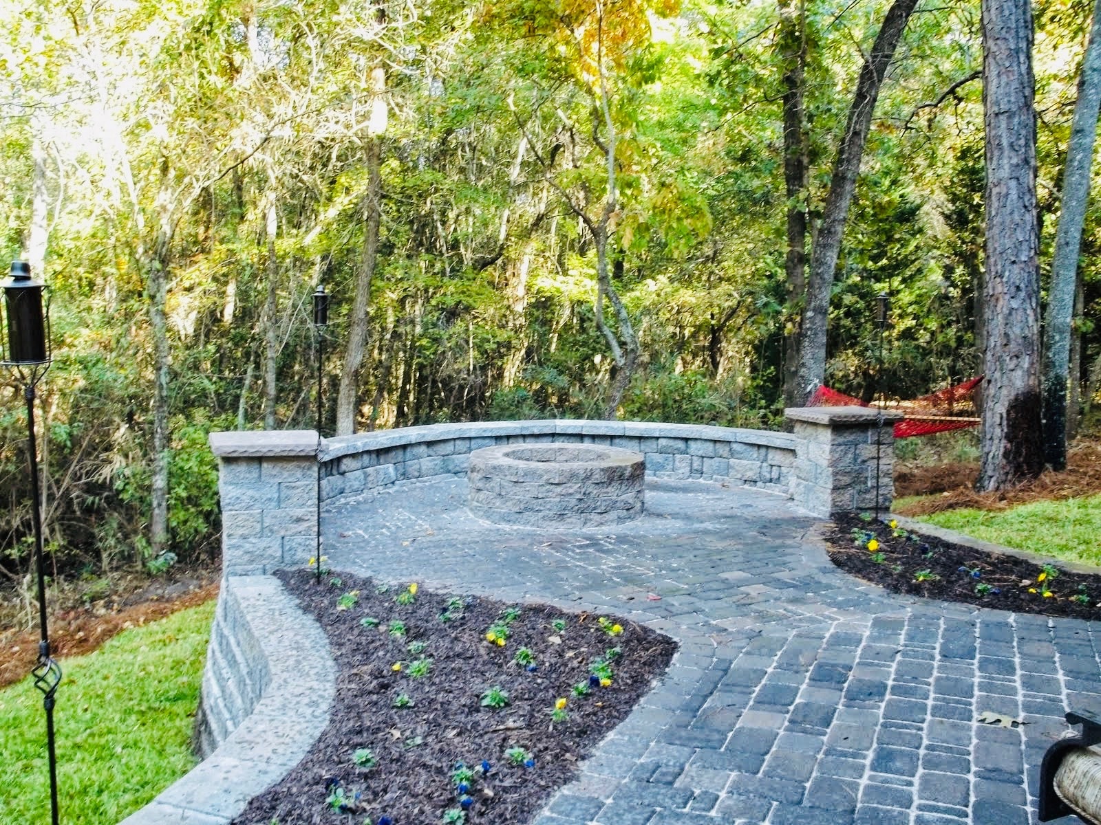 Stone patio with seating wall and forest backdrop